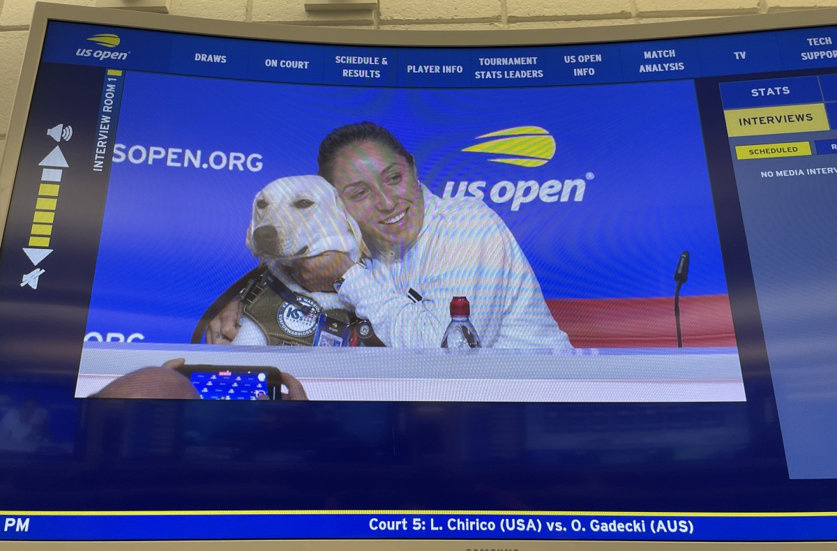 会見で救助犬をハグするペグラ。犬好きとしても有名