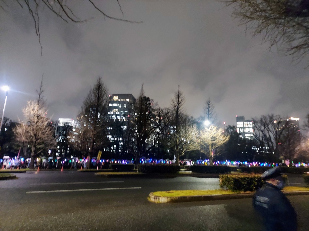 対岸の歩道に長く長く伸びるペンライトの波