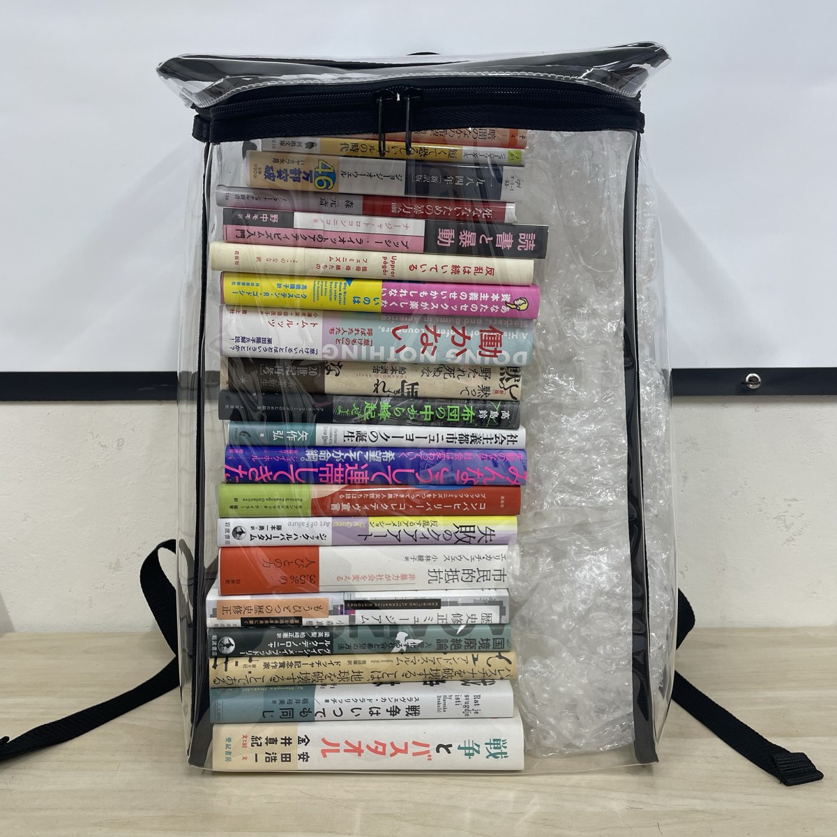 本日のお品書きです。透明なバックパックに現実を見据える本と元気が出る本が詰まっていますね。