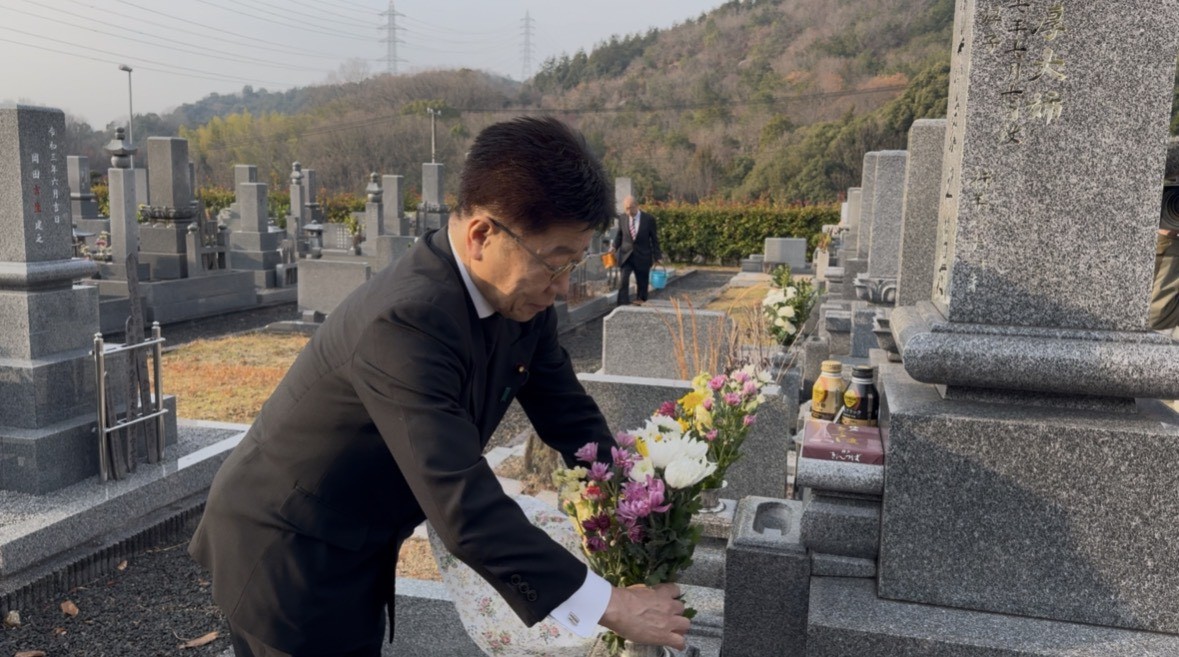 赤木俊夫さんの墓前に花を供える加藤前財務大臣（提供・日本中学生新聞）