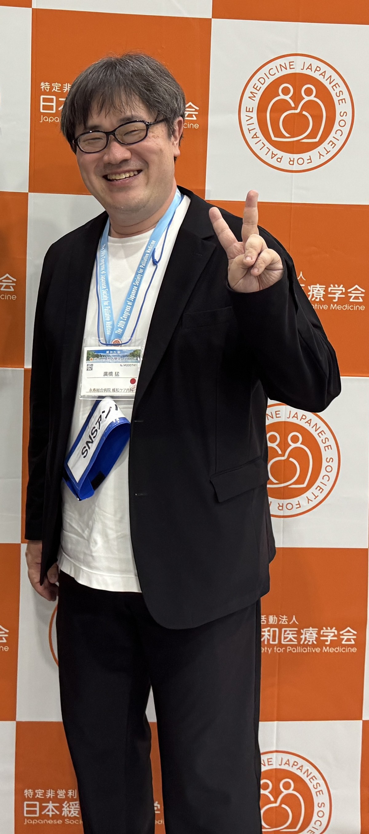学会のブースにて撮影に応じる筆者