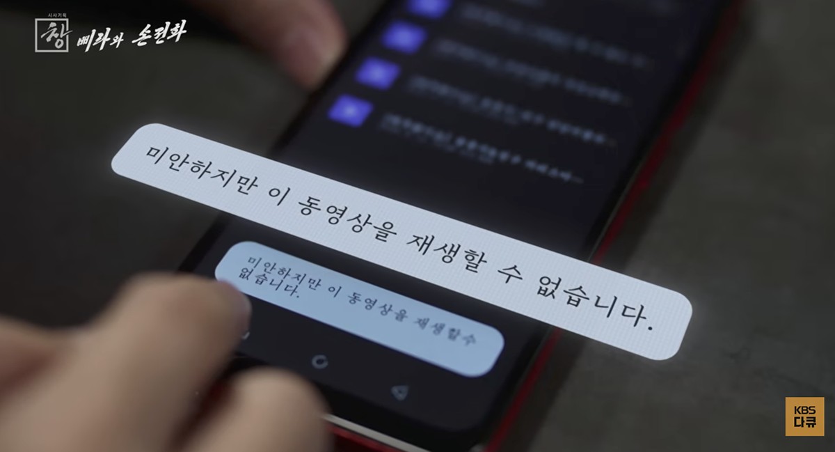 検証の場面。「申し訳ありませんが、この動画を再生できません」と表示されています。スマホには他にも「オッパ(女性が使うお兄さんを指す呼称)」が入力できないなど、韓国式の文化を遮断する機能が搭載されていました。同番組をキャプチャ。
