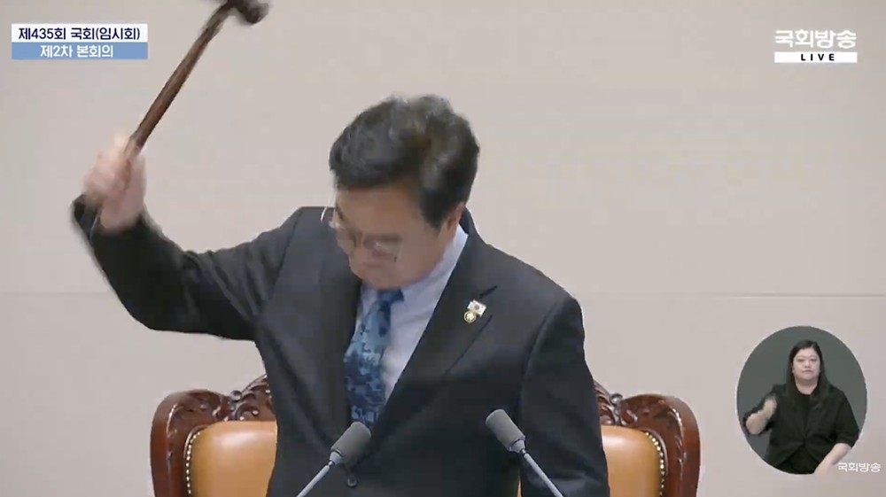 渾身の力で議事棒を振り下ろす禹元植国会議長。国会放送をキャプチャ。