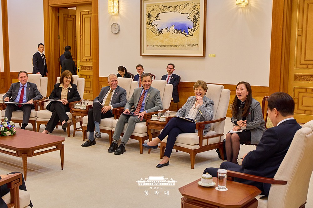 米議員代表団と歓談する李在明大統領。左手をあごに当て、足を組んで笑う右から3番目の女性がジーン・シャヒーン米上院議員。青瓦台提供。