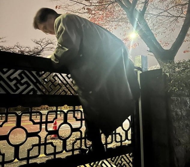 24年12月3日の非常戒厳の際、塀を越えて国会に入る禹元植国会議長。戒厳にあらがう国会を象徴する一枚です。国会議長室提供。