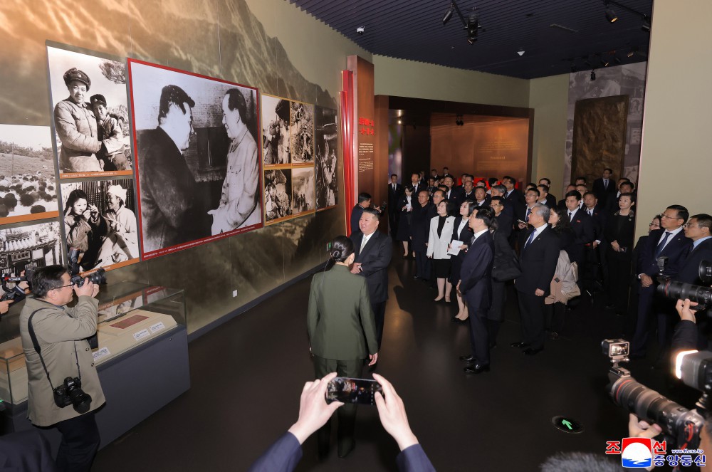 24日、抗美援朝記念館を訪問した金正恩氏（中央）。壁の大きな写真は金日成と毛沢東だ。朝鮮中央通信より引用。