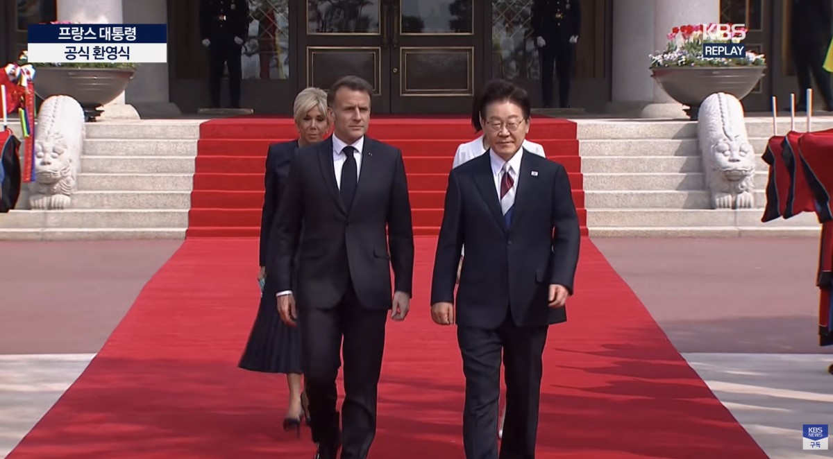 3日、青瓦台でマクロン大統領を出迎える李在明大統領。ネクタイがトリコロール柄でした。KBSをキャプチャ。