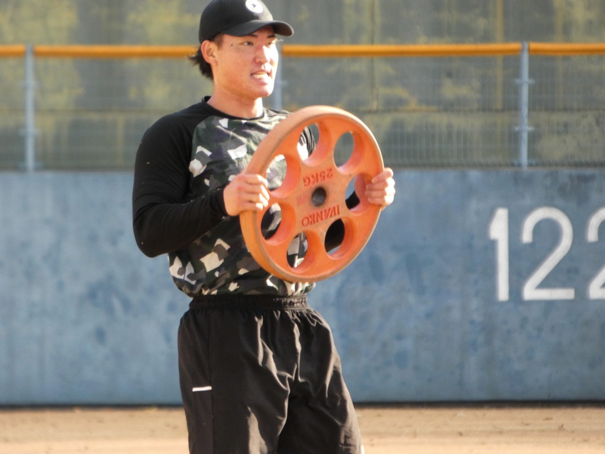 山川塾での重松選手。ノックの合間に、25ｋｇのプレートを持ちながらのトレーニング