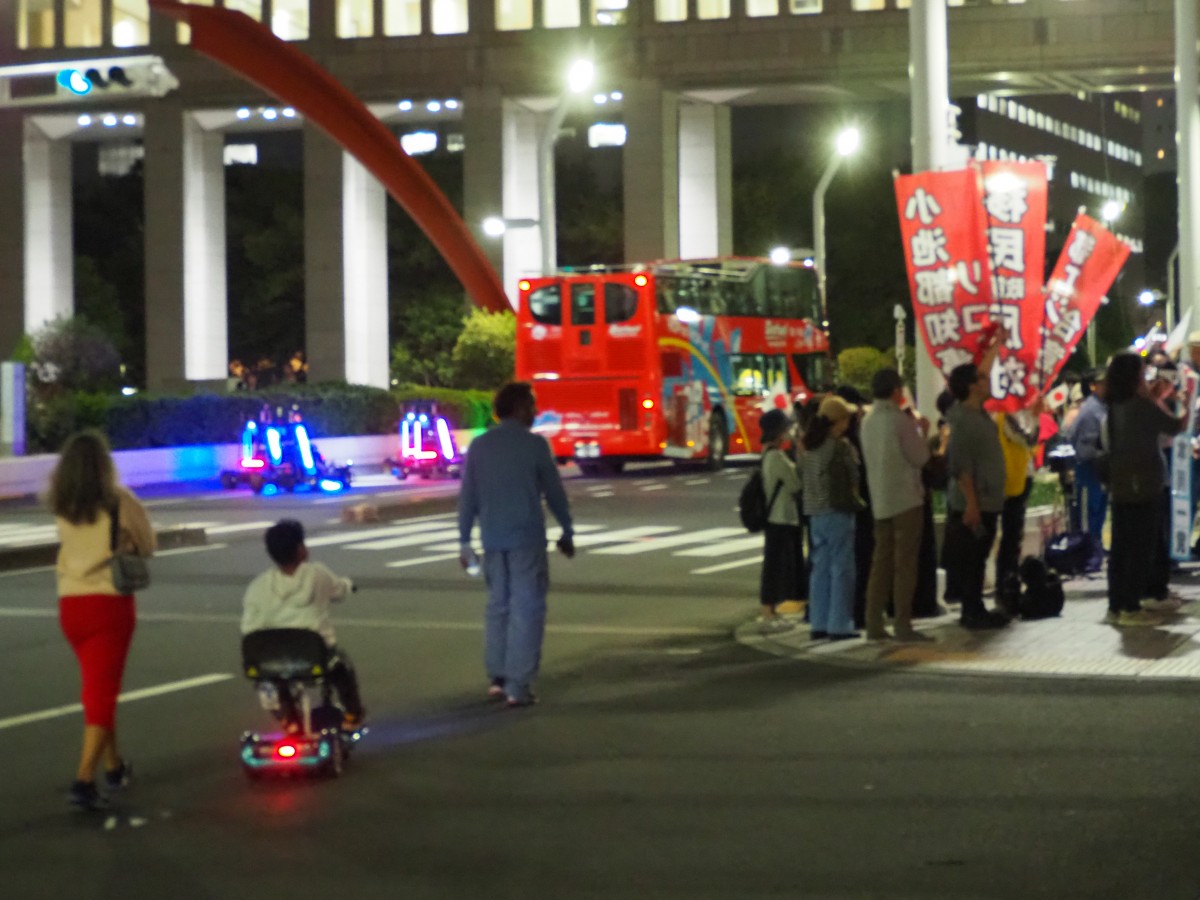 (マリオカートに気付かないデモ隊。手前も外国人のご家族)