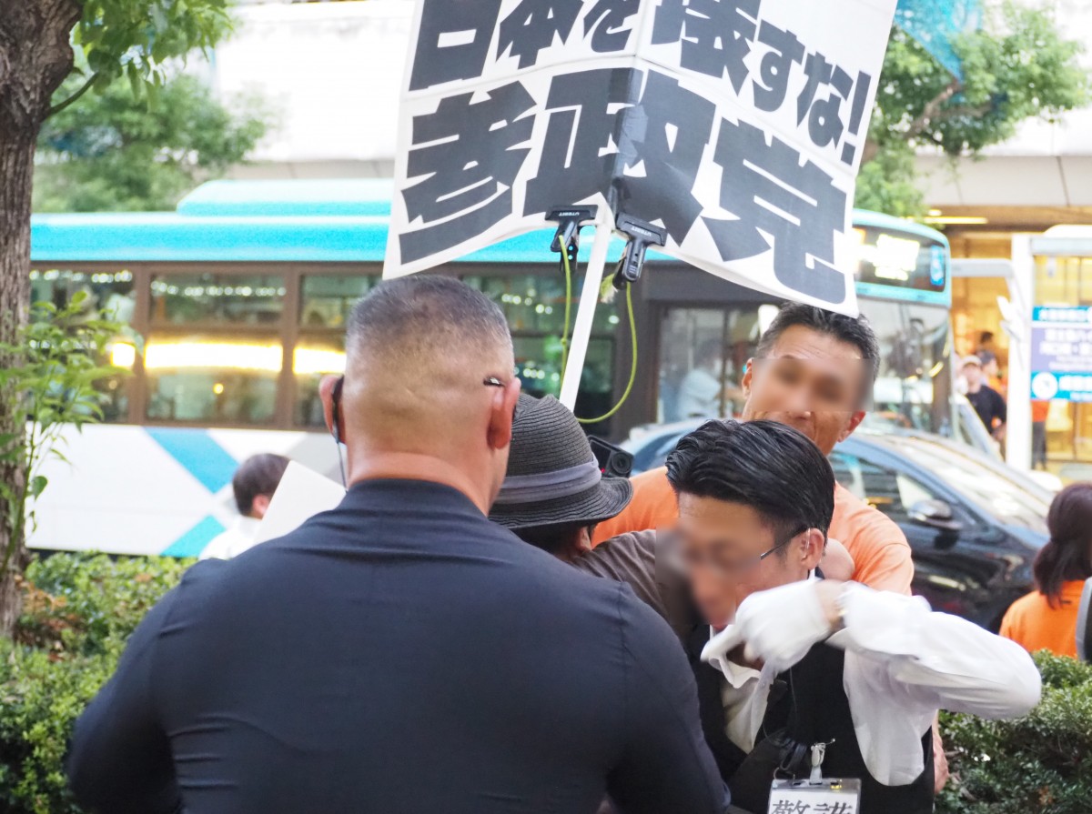 (参政党スタッフと抗議者の揉みあい)