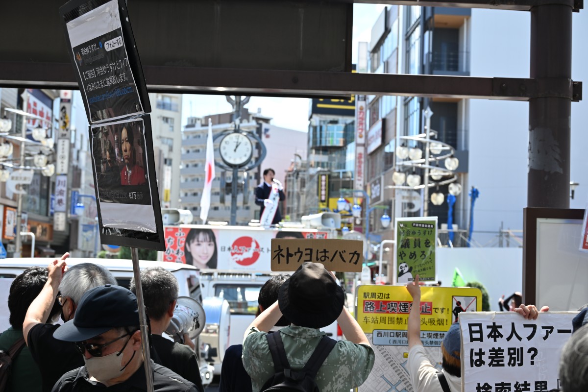 （駅の下から河合に抗議する方々）