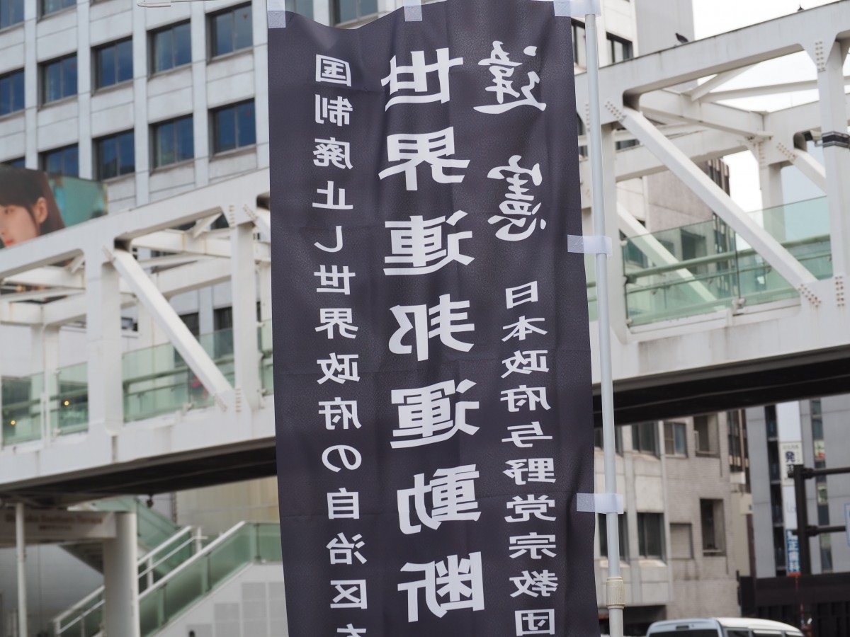 (新宿南口で黒い旗が揺れる)