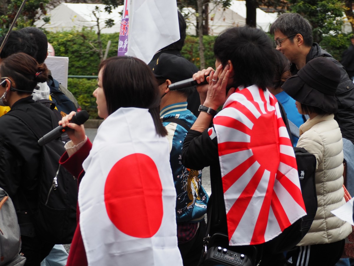 （マイクを持つデモ行進参加者）