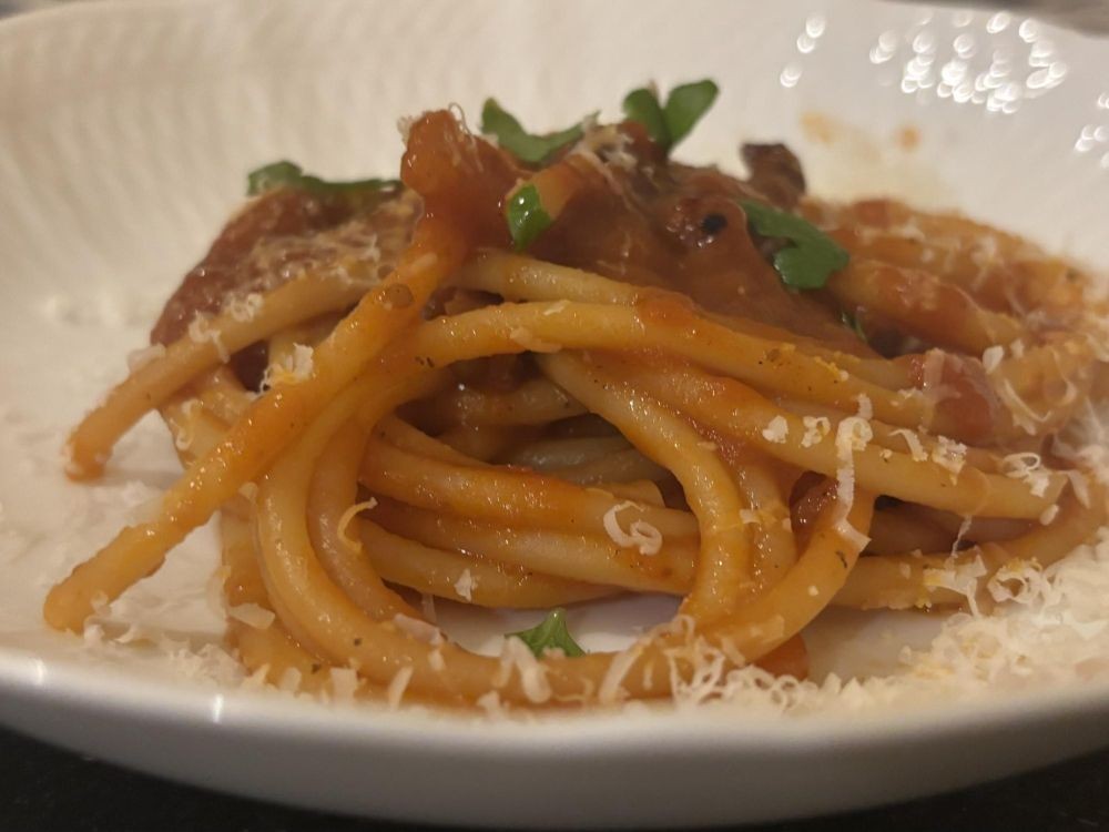 パスタは太くて中に細い穴が開いているブカティーニ <Bucatini>。口に含んだ時に、その隙間からの空気が口の中に入り、今まで味わった事のない食感。さらにベーコンとの凝縮されたソースとチーズとの相性も素晴らしい