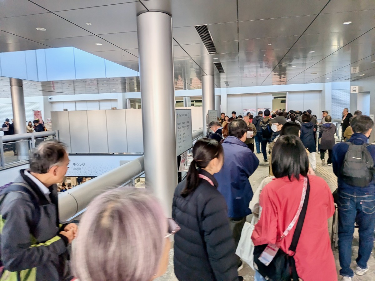 会場内。施設のエントランスから観客席まで人でいっぱい。区民体育館のような施設に満場の人だかり。