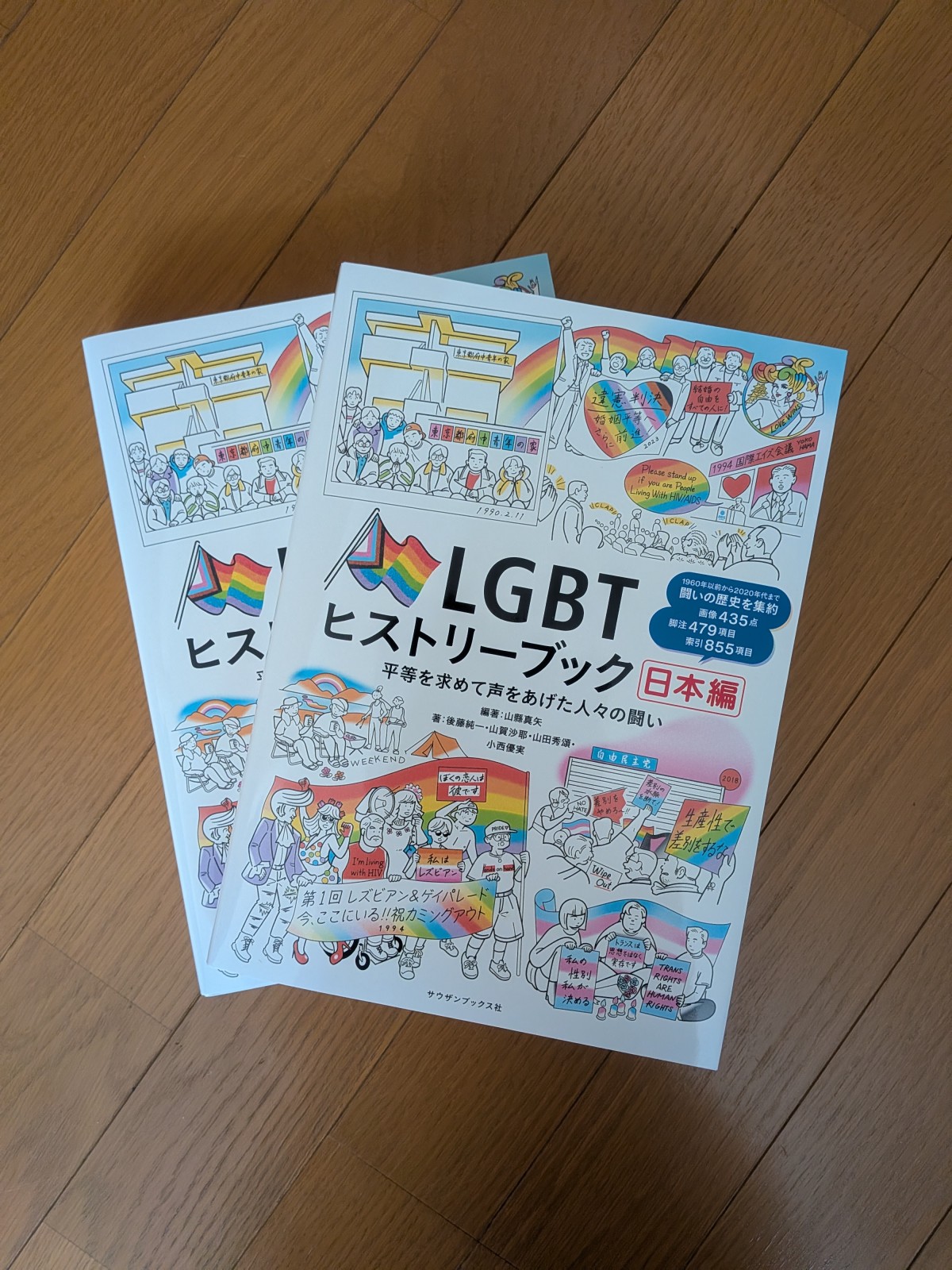 本の表紙。LGBTヒストリーブック日本編の表題の周辺に線画のイラストがあしらってある。レインボーフラッグも描かれている