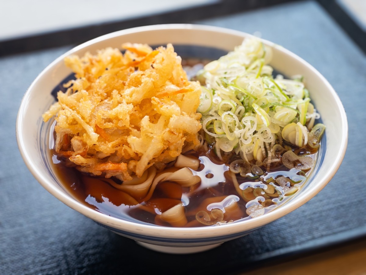 『どんどん庵』の「きしめん(並)」に「野菜のかき揚げ」をトッピング。たっぷりのネギとともに天ぷらをいただくのがツウ好みの食べ方だ=筆者撮影