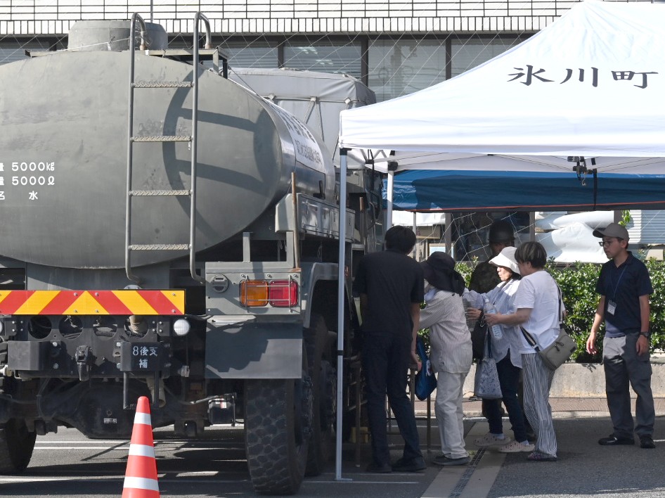 熊本県氷川町で自衛隊による給水に並ぶ人たち=7月30日、川柳まさ裕撮影
