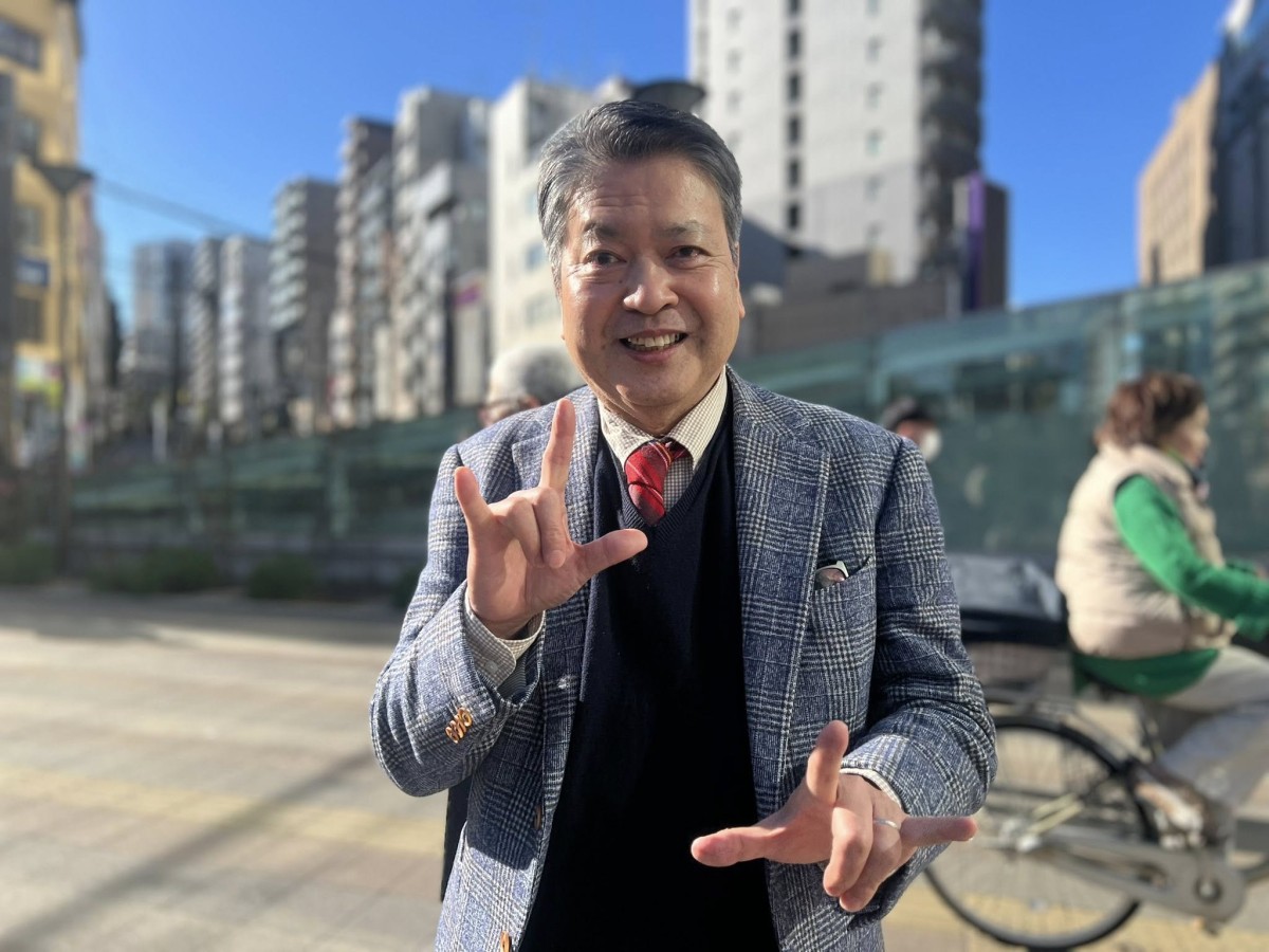 アメリカ手話で「I LOVE YOU」とやってみせてくれた藤坂康司さん(撮影・岩永直子)