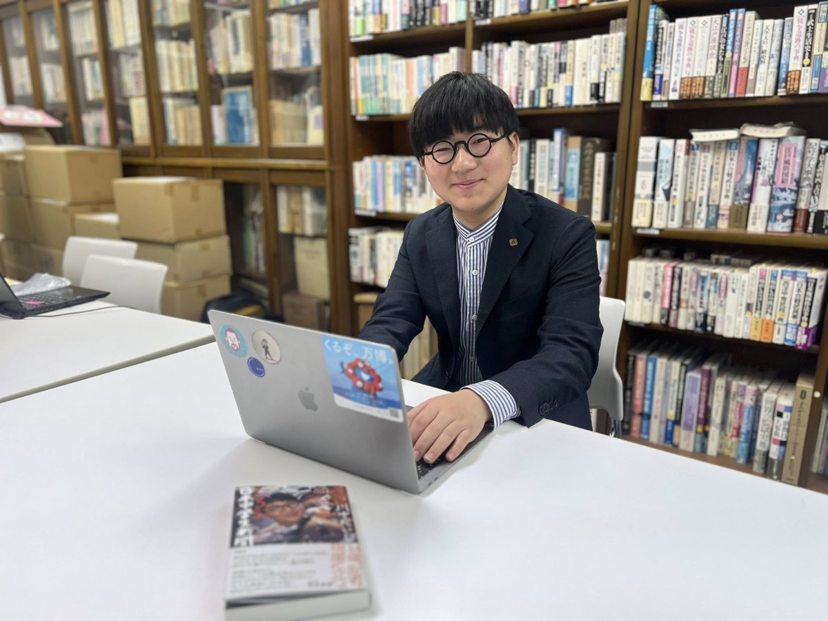 愛用のパソコンとポーズを取る川中だいじさん