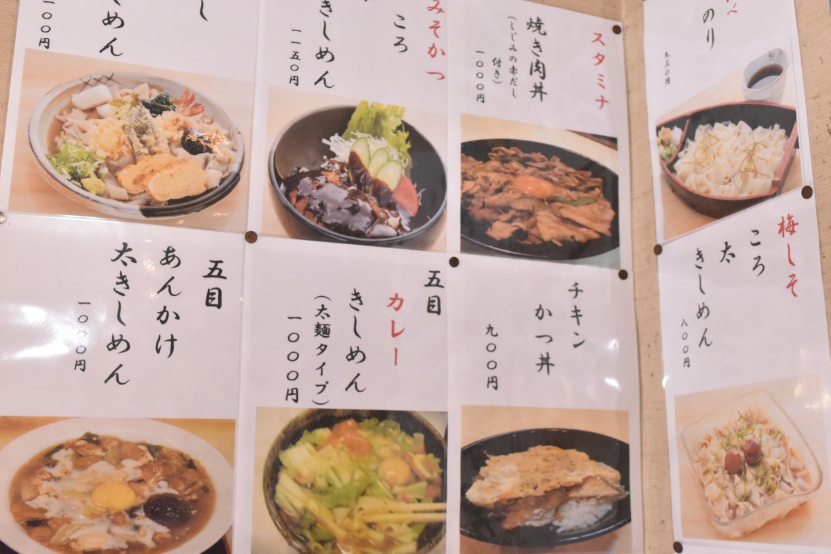オリジナリティあふれるきしめんをはじめとするメニューの写真が壁中に貼られている