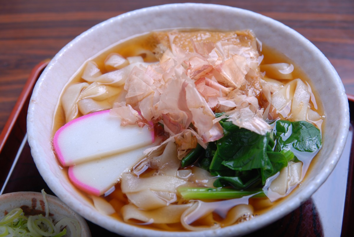 温かいきしめんももちろん美味。油揚げ、かまぼこ、ほうれん草(わかめに替わる時もあり)、そしてたっぷりの花かつおが踊る。770円