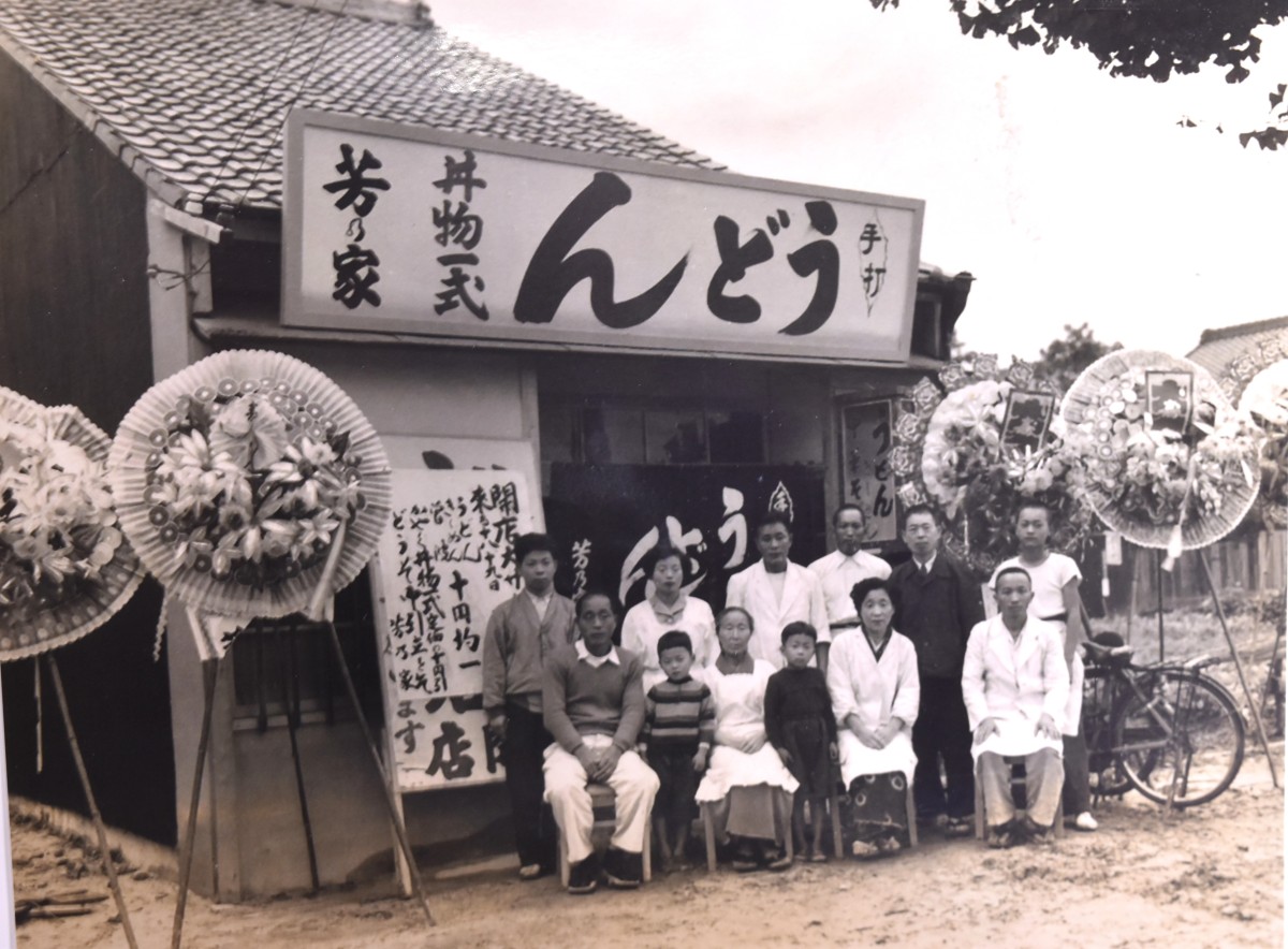 昭和27年（頃）の開店時の記念写真。四国から出てきた野崎さんの両親（後列左から2、3人目）が、姉夫婦（前列右）が営む名古屋市中村区のうどん屋で修行した後、現在の場所で開業した