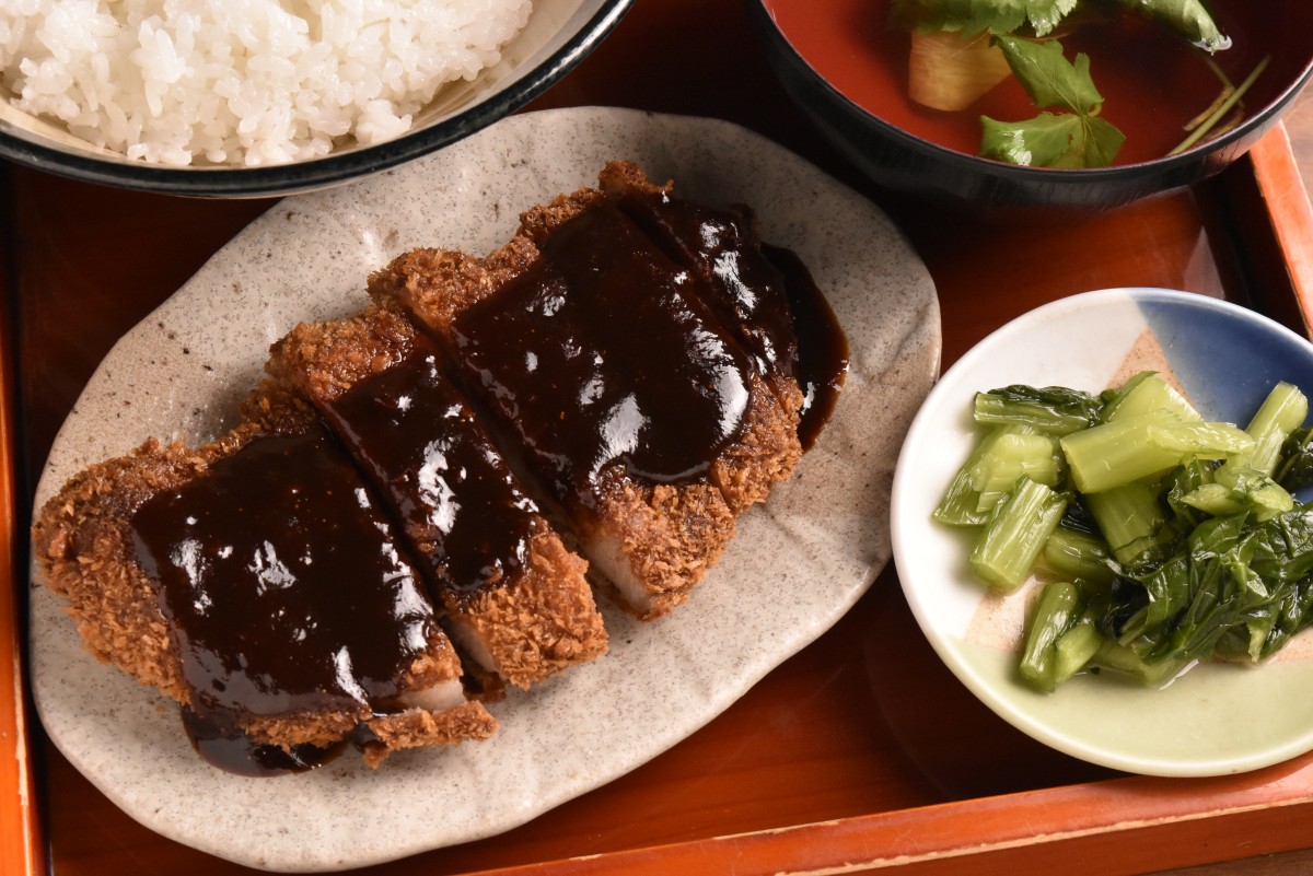 実は味噌かつもおいしい。味噌煮込みうどん用の4種の味噌のうち1種を使って味噌ダレをつくり、信州豚をラードで揚げて食べ応えも十分。味噌かつ丼は写真のようにカツが別添えで出てくる。1100円
