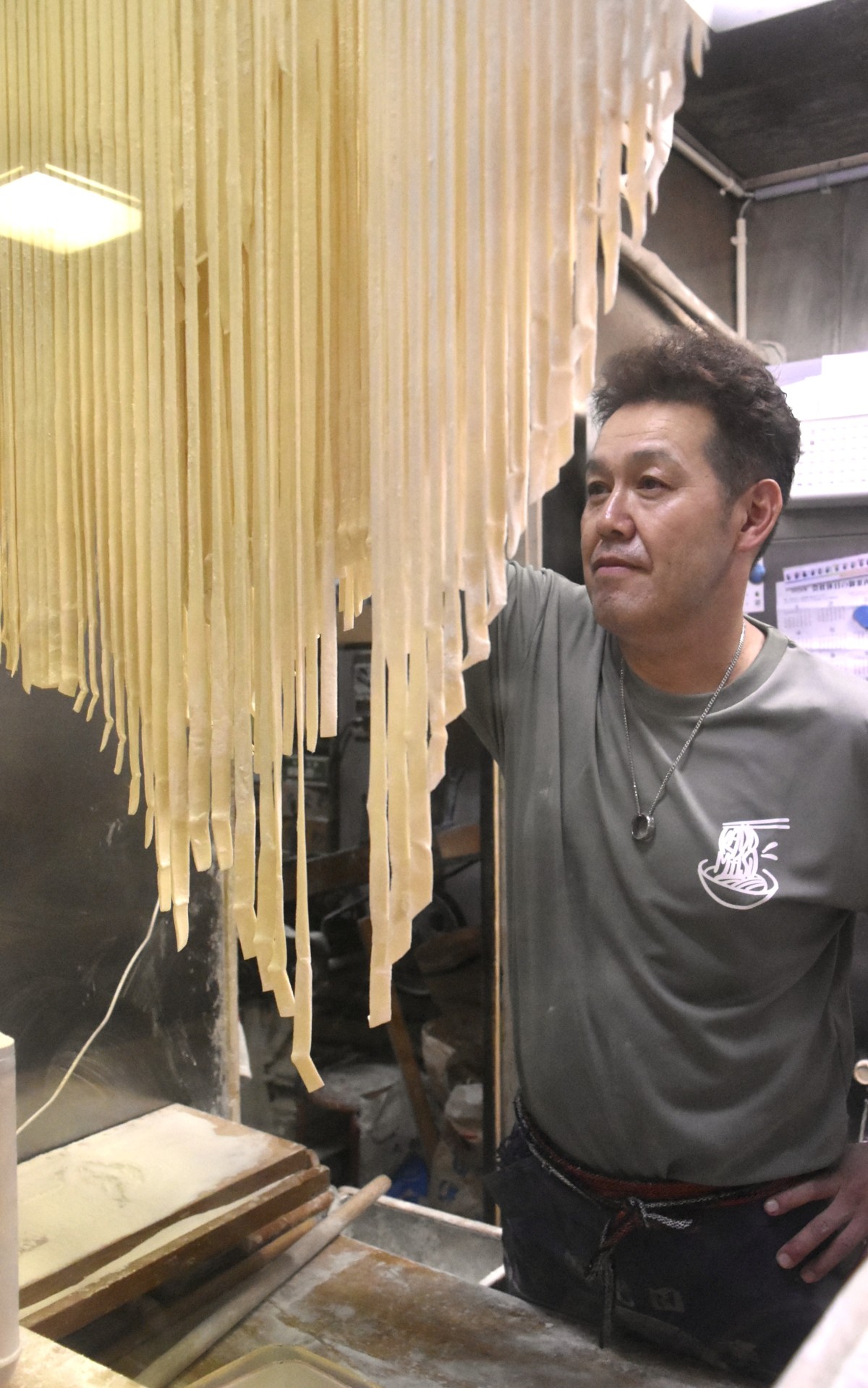 4代目の佐野敬徳(よしのり)さん。麺は切った後でつるして乾かすことで、ゆでる際に麺同士がくっつかなくなる。「つるしても伸びてしまわないよう力強い粉をつかっています」