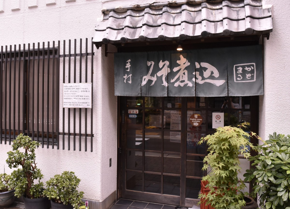 「みそ煮込みのかどまる」の入口には「手打みそ煮込」と染め抜かれたのれんが。場所は中部電力MIRAI TOWER（名古屋テレビ塔）から歩いて10分ほど。最寄りの久屋大通駅は名古屋駅から地下鉄で5分