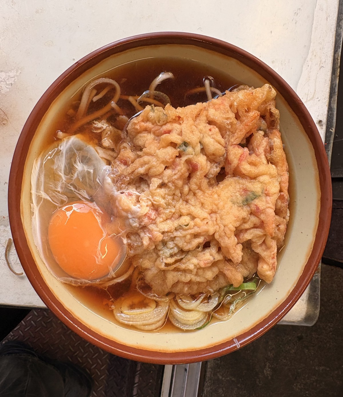 外にある、なかなか歴史を感じるテーブルの上に、天玉そばを置いて、写真を撮った。このあと、おじいさんに一喝される。