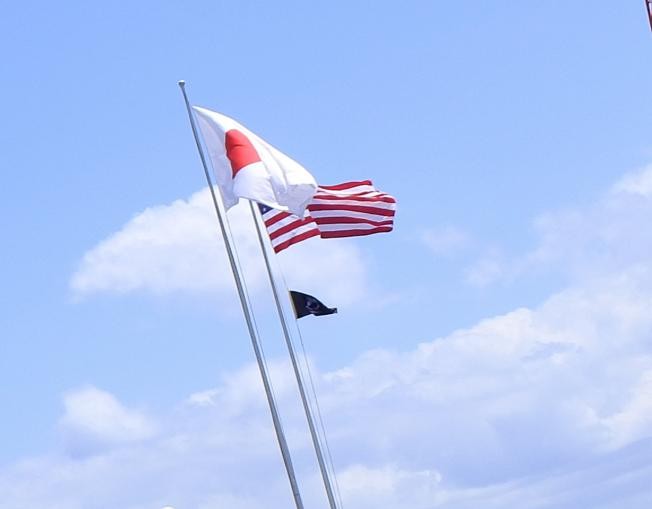 在日米軍に掲げられる、日章旗・星条旗。この下に見える黒い旗（POW/MIA FLAG）アメリカ国旗以外でホワイトハウスに掲揚された唯一の旗である。現在では、アメリカ国旗が掲揚される日は毎日、すべての主要な連邦政府施設でこの旗を掲揚することが法律で義務付けられている。　著者撮影