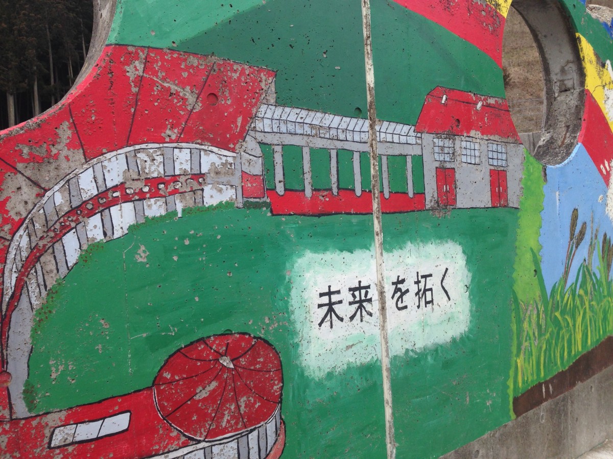 遺構となった校舎跡の野外ステージ壁面には「未来を拓く」の文字が刻まれている。校歌のタイトルでもある（15年2月22日、撮影：渋井哲也）