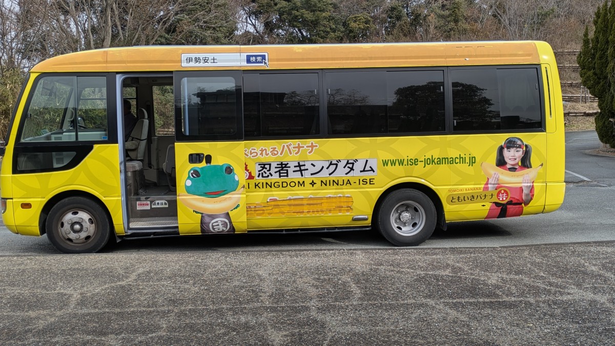 「ともいきバナナ」の宣伝ラッピングが施された送迎バス。「17時から入場無料！」の文字が消されている。