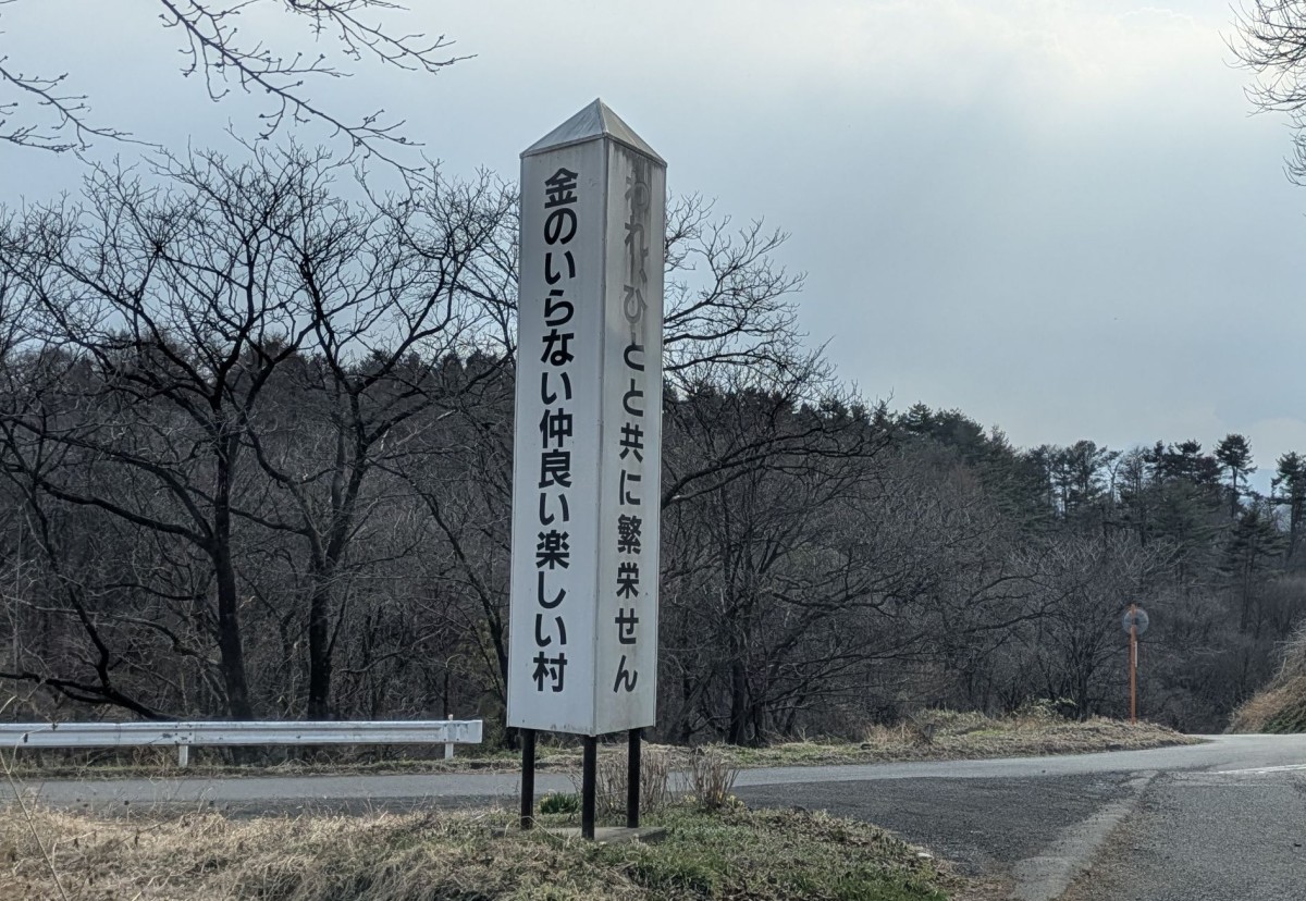 今も残る「金のいらない仲良い楽しい村」のスローガン。