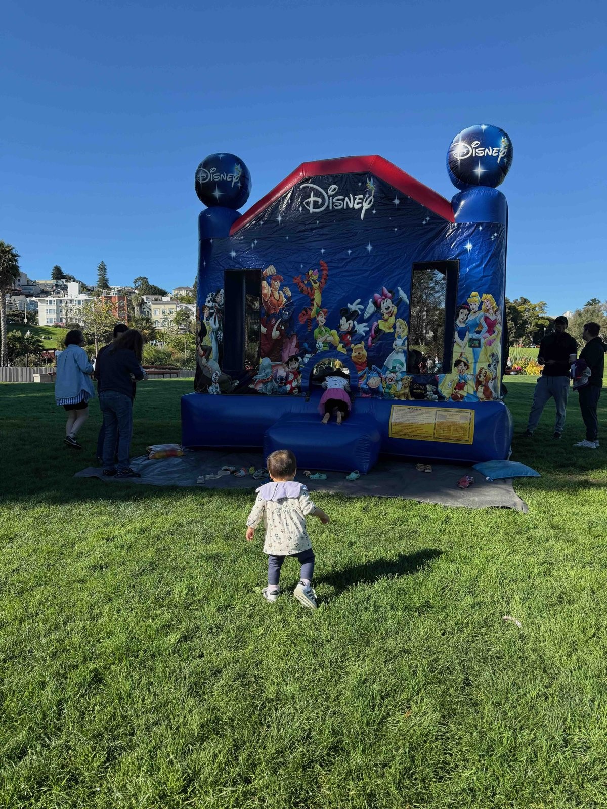 お姉さんの友達の誕生日会にセットアップされたバウンスハウスに向かう次女