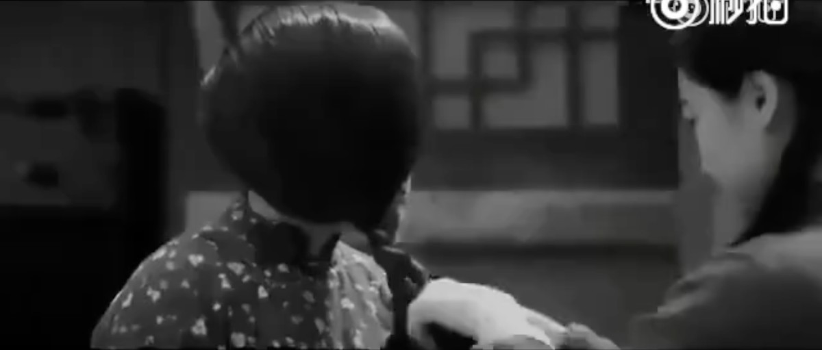 中国農民の衣服を与えられ、村の女の子に髪を三つ編みにしてもらう貞子。人民の温情。