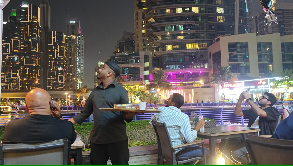爆発音がした空を見上げるレストランの客と従業員＝2月28日午後7時ごろ、ドバイ・マリーナ（写真はすべて村山祐介撮影）